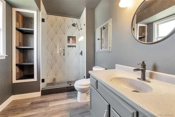 a bathroom with a granite countertop toilet sink and shower