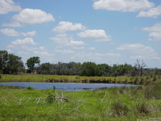 a view of a green field with wooden fence