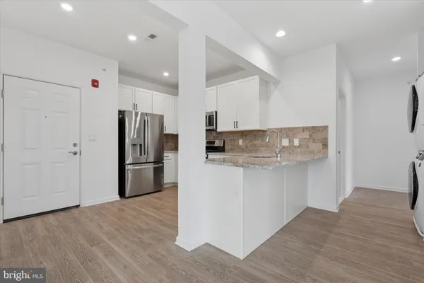 a kitchen with stainless steel appliances a refrigerator and a stove top oven