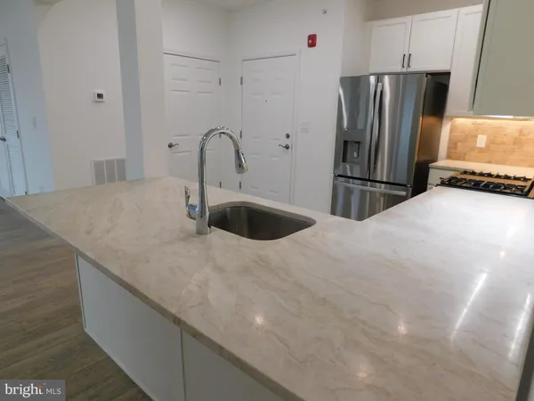 a kitchen with stainless steel appliances a refrigerator and a counter space