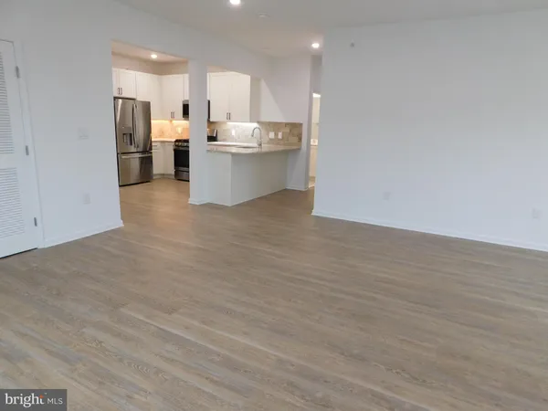 a view of kitchen with kitchen island wooden cabinets and refrigerator