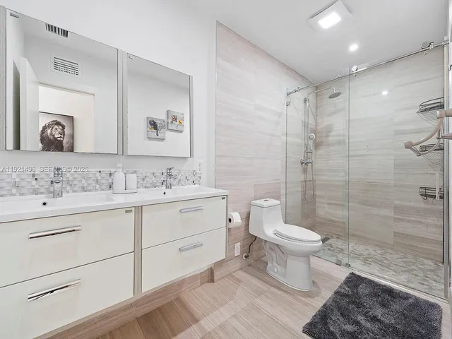 a bathroom with a sink toilet a mirror and shower