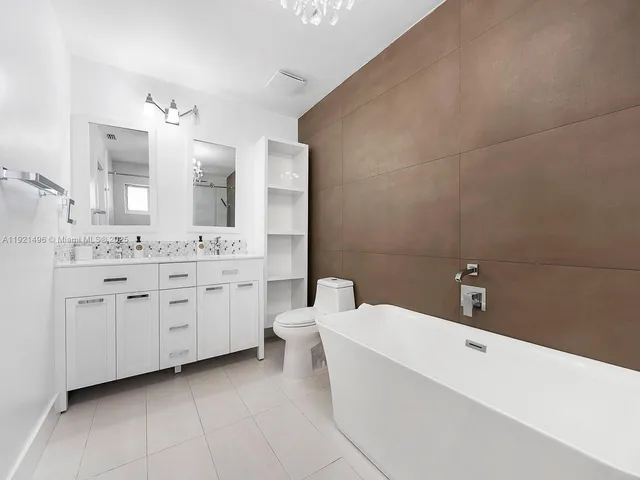 a bathroom with a double vanity sink a mirror and a bathtub