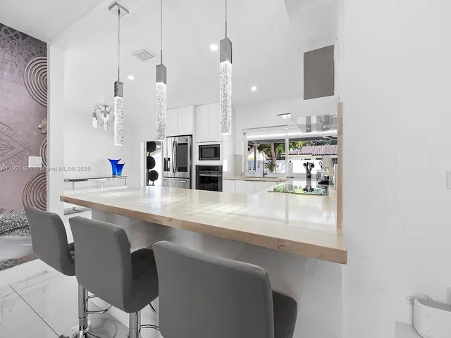 a kitchen with stainless steel appliances granite countertop a sink a stove and a wooden floor