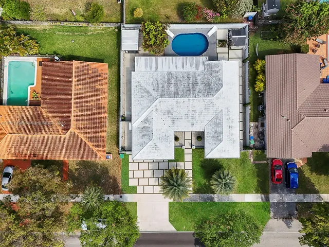 an aerial view of a house with a yard and a fountain