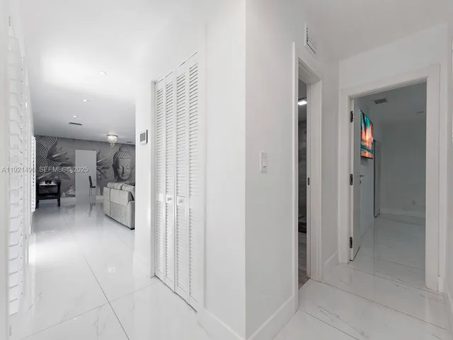a view of a hallway with a livingroom and furniture