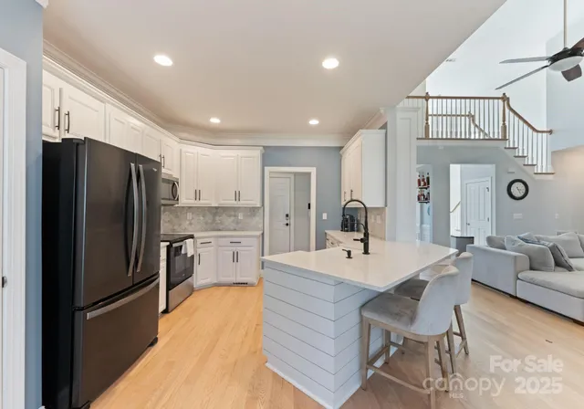 a kitchen with a refrigerator a sink and chairs