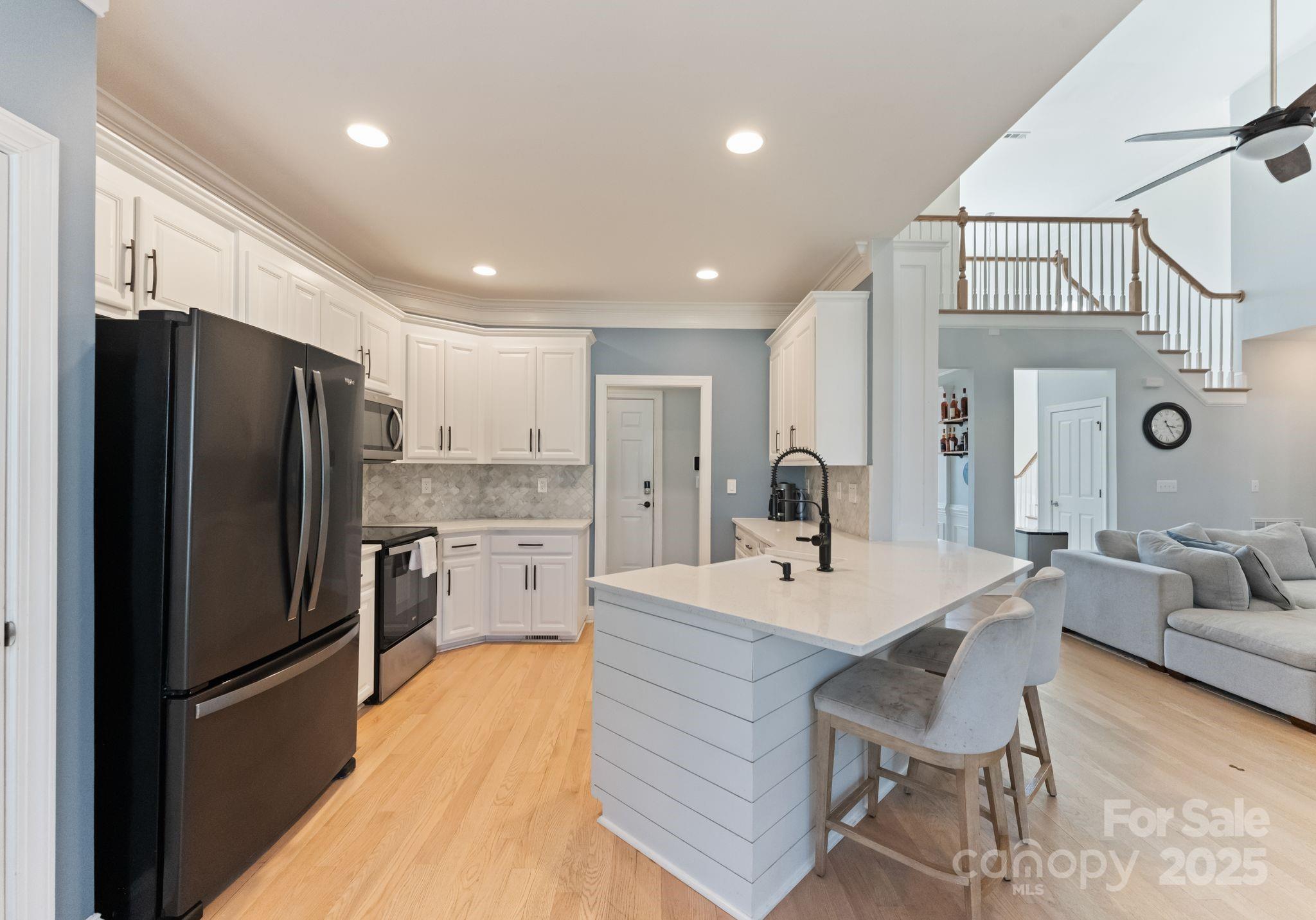 706 King Fredrick Lane Southwest Concord, NC 28027 - Photo 11 of 36 a kitchen with a refrigerator a sink and chairs