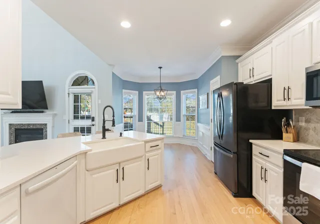 a kitchen with granite countertop a refrigerator stove microwave and sink
