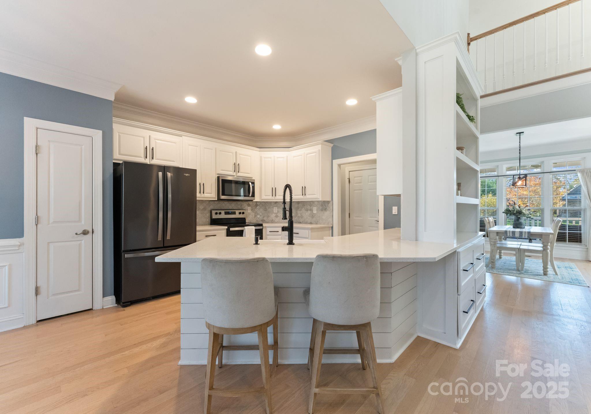 706 King Fredrick Lane Southwest Concord, NC 28027 - Photo 13 of 36 a kitchen with stainless steel appliances a dining table chairs refrigerator and sink