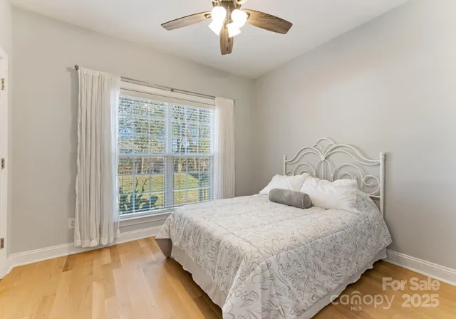 a bedroom with a large bed and a chandelier fan