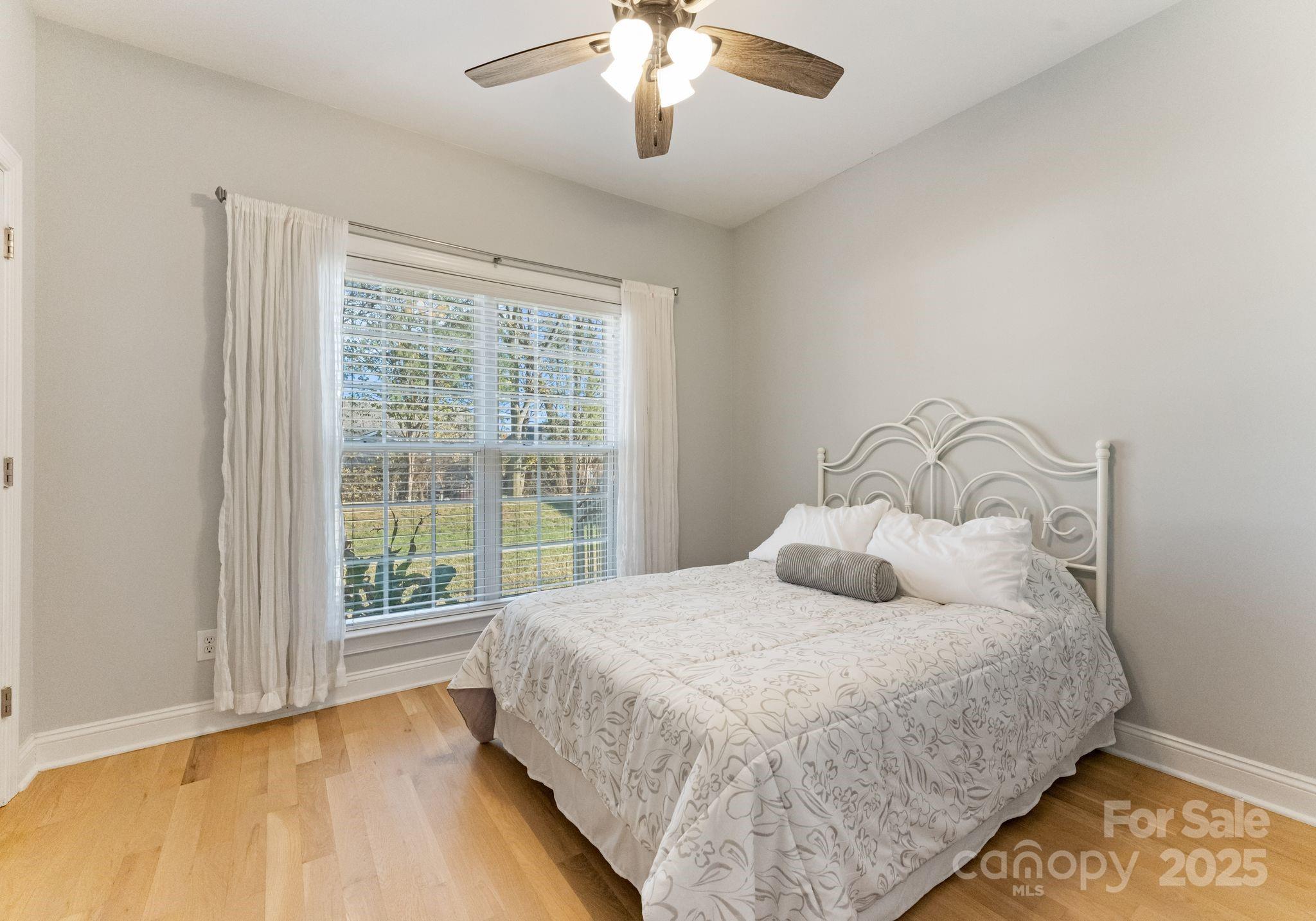706 King Fredrick Lane Southwest Concord, NC 28027 - Photo 23 of 36 a bedroom with a large bed and a chandelier fan