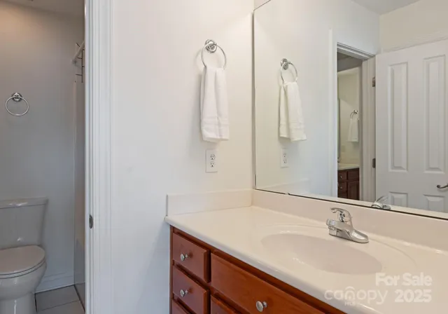 a bathroom with a granite countertop sink a toilet and a mirror