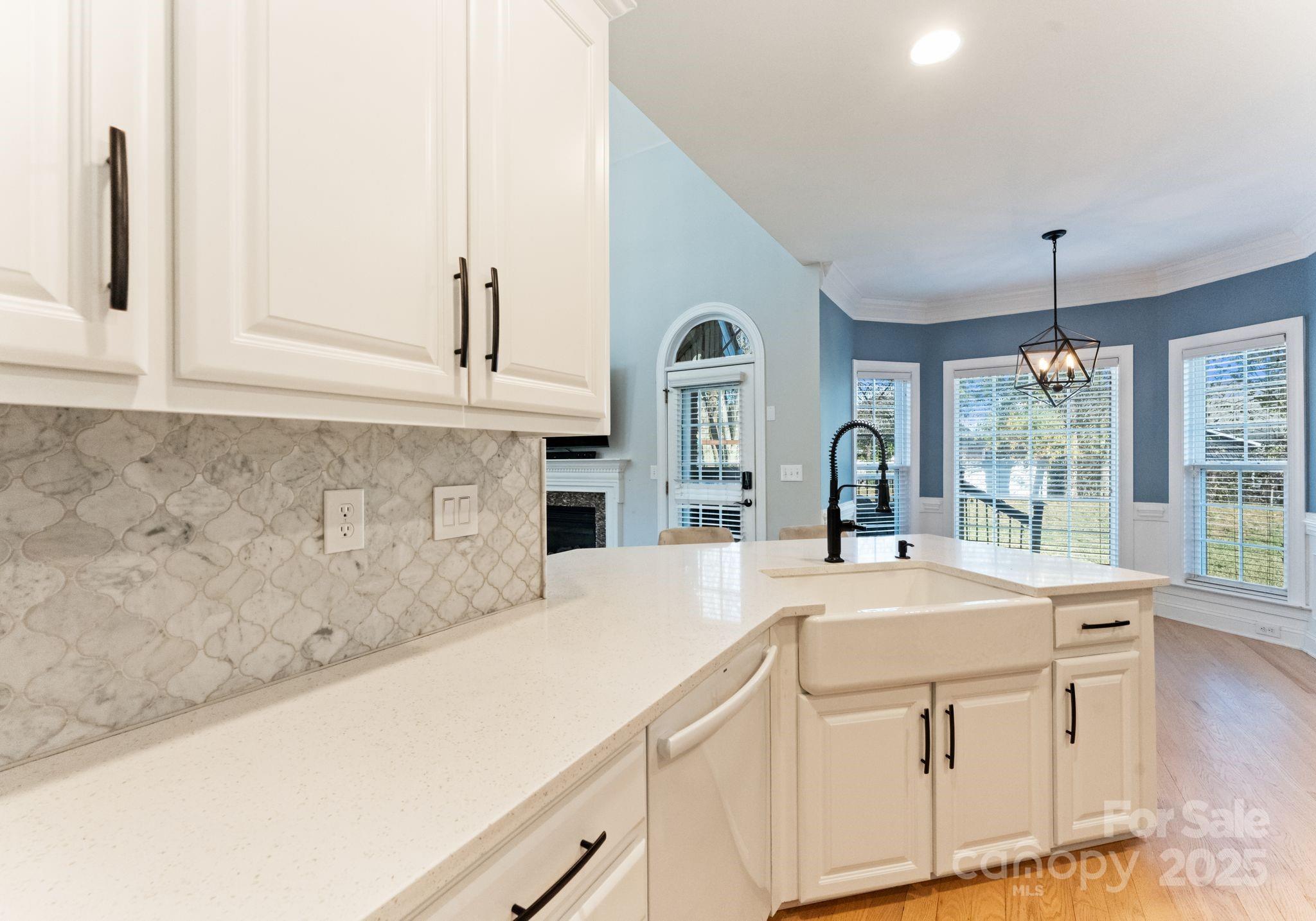706 King Fredrick Lane Southwest Concord, NC 28027 - Photo 9 of 36 a large white kitchen with granite countertop a sink and white cabinets with wooden floor