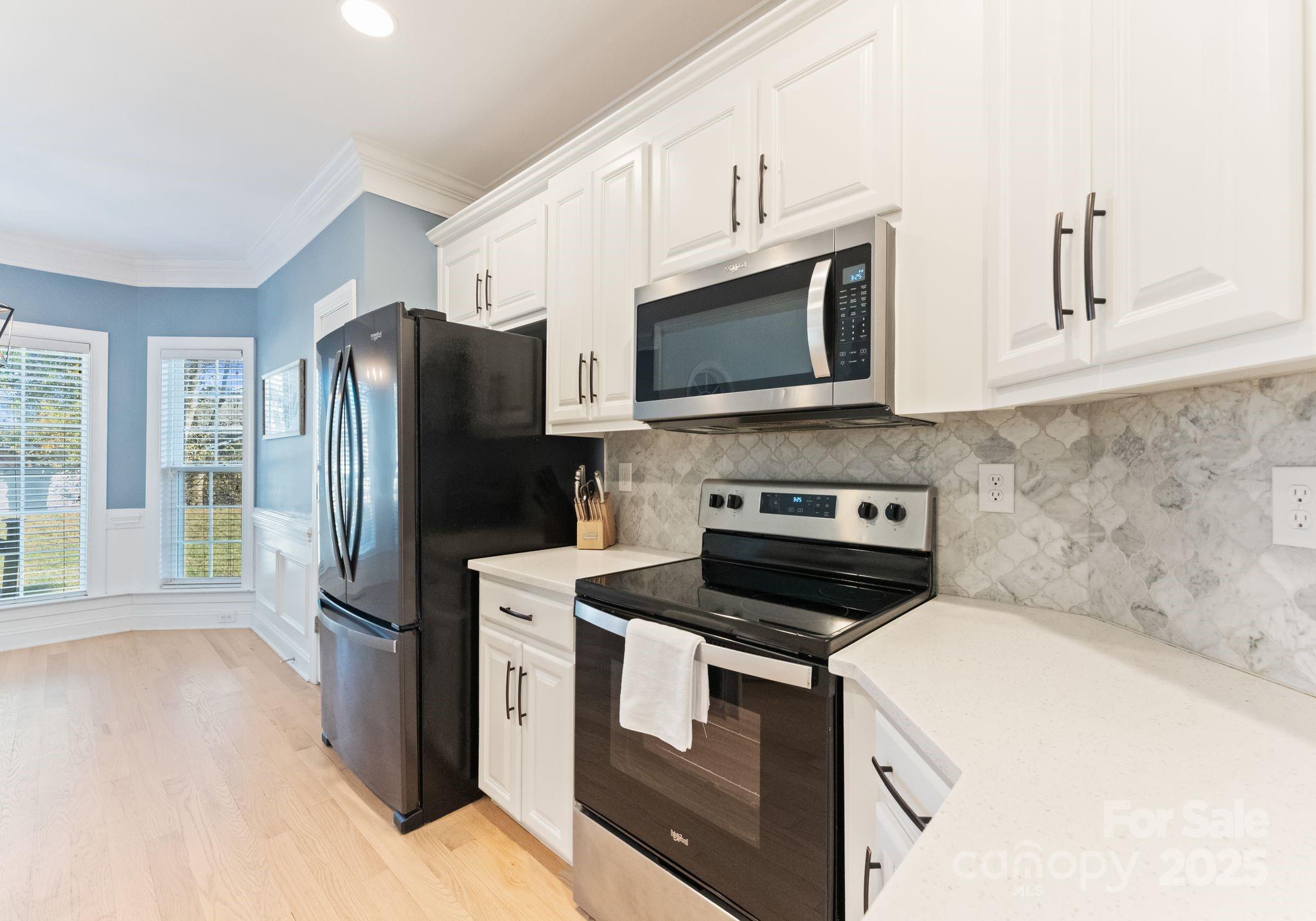 706 King Fredrick Lane Southwest Concord, NC 28027 - Photo 10 of 36 a kitchen with stainless steel appliances a stove microwave and refrigerator