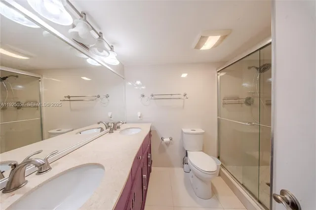 a bathroom with a granite countertop sink a toilet and a shower
