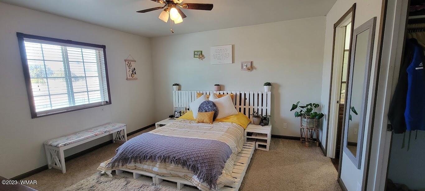 741 South 7th W Street Snowflake, AZ 85937 - Photo 13 of 41 a bedroom with a bed and a chandelier fan