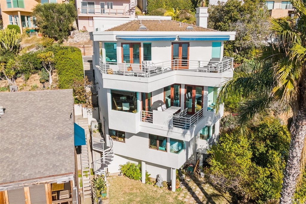 2485 Kilo Way Laguna Beach, CA 92651 - Photo 2 of 35 a view of a white house with a table and chairs under an umbrella