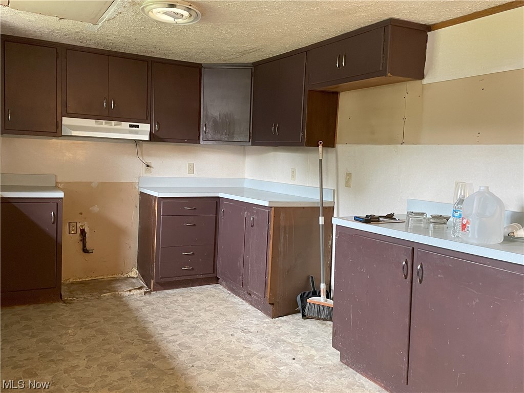 4107 Jaeger Road Lorain, OH 44053 - Photo 7 of 33 Kitchen with dark brown cabinets, light tile floors, and a textured ceiling