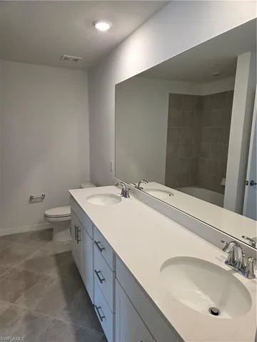 a bathroom with a double vanity sink toilet and mirror