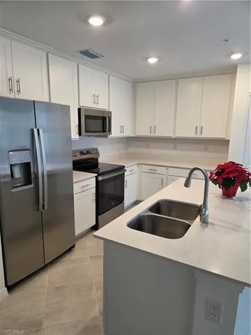 a kitchen with cabinets a sink and stainless steel appliances