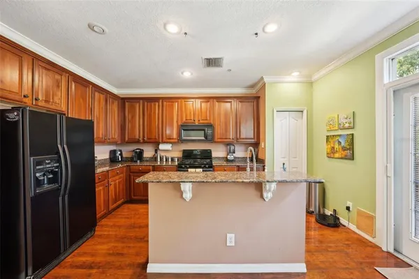 a kitchen with stainless steel appliances granite countertop a refrigerator stove top oven and sink