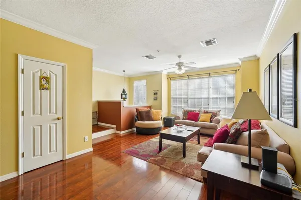 a living room with furniture and a wooden floor