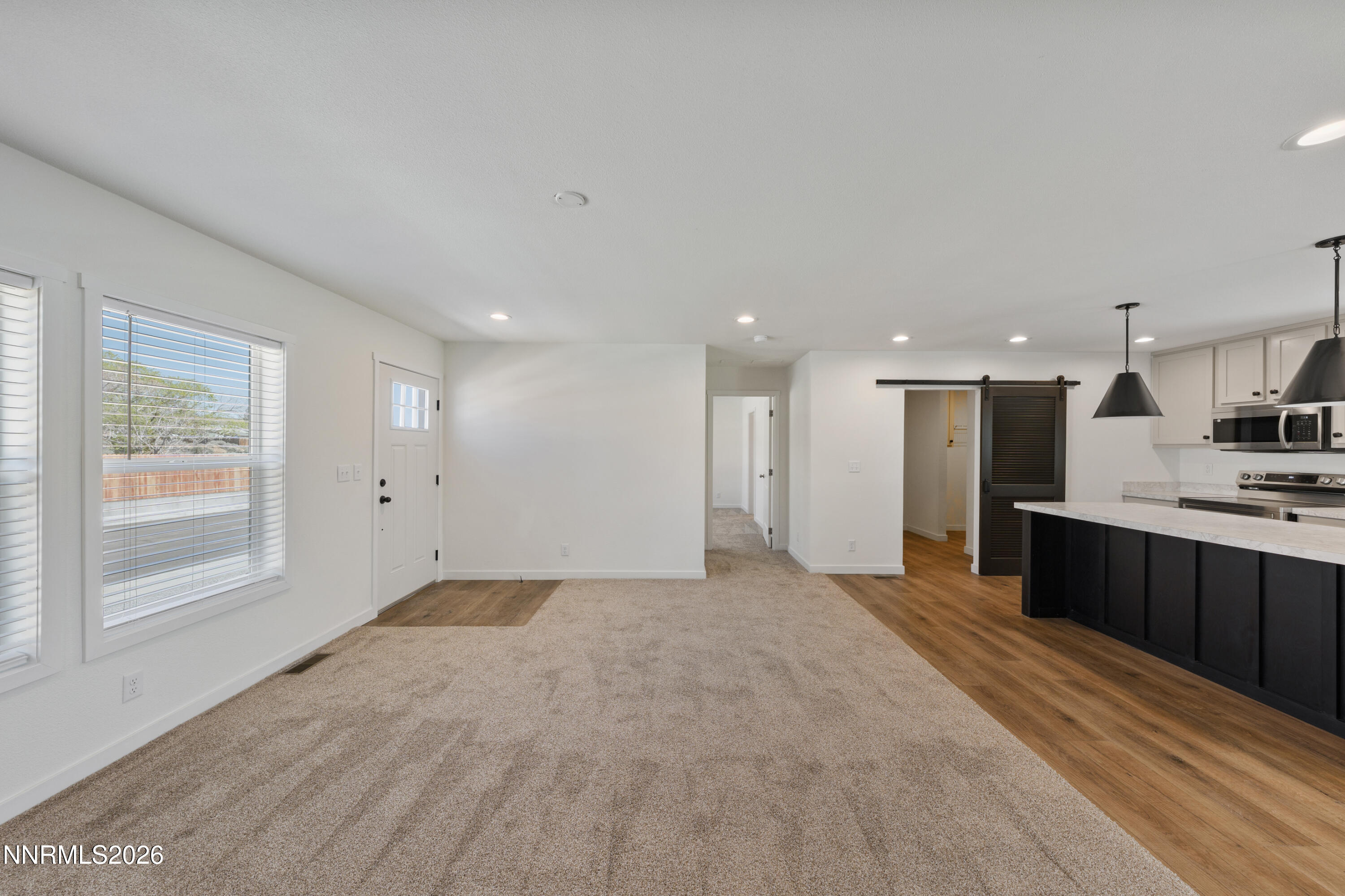 242 Caleb Court Sun Valley, NV 89433 - Photo 13 of 24 a view of a kitchen with kitchen island a sink wooden floor and black appliances