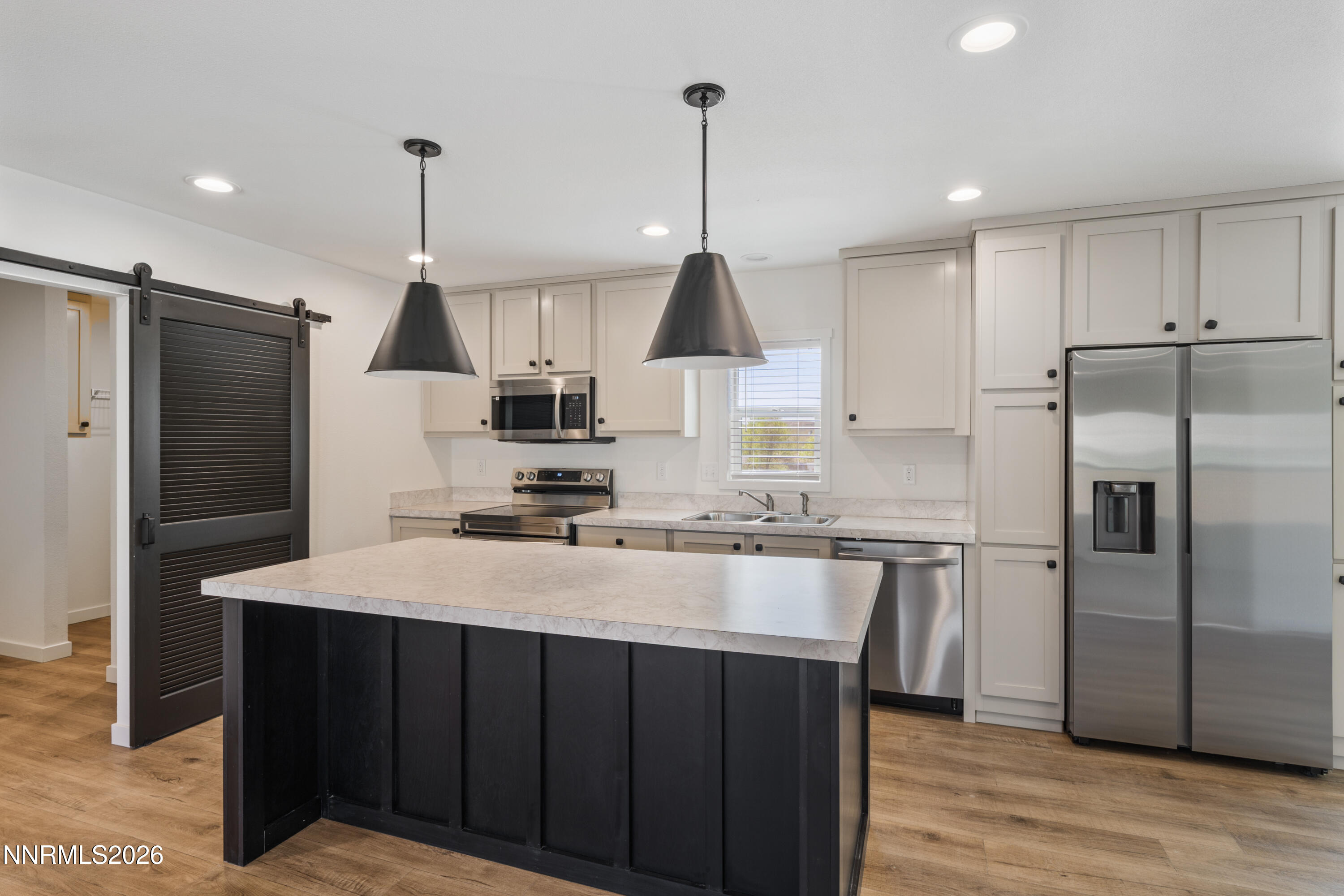 242 Caleb Court Sun Valley, NV 89433 - Photo 6 of 24 a kitchen with stainless steel appliances granite countertop a refrigerator a sink dishwasher a stove and a refrigerator