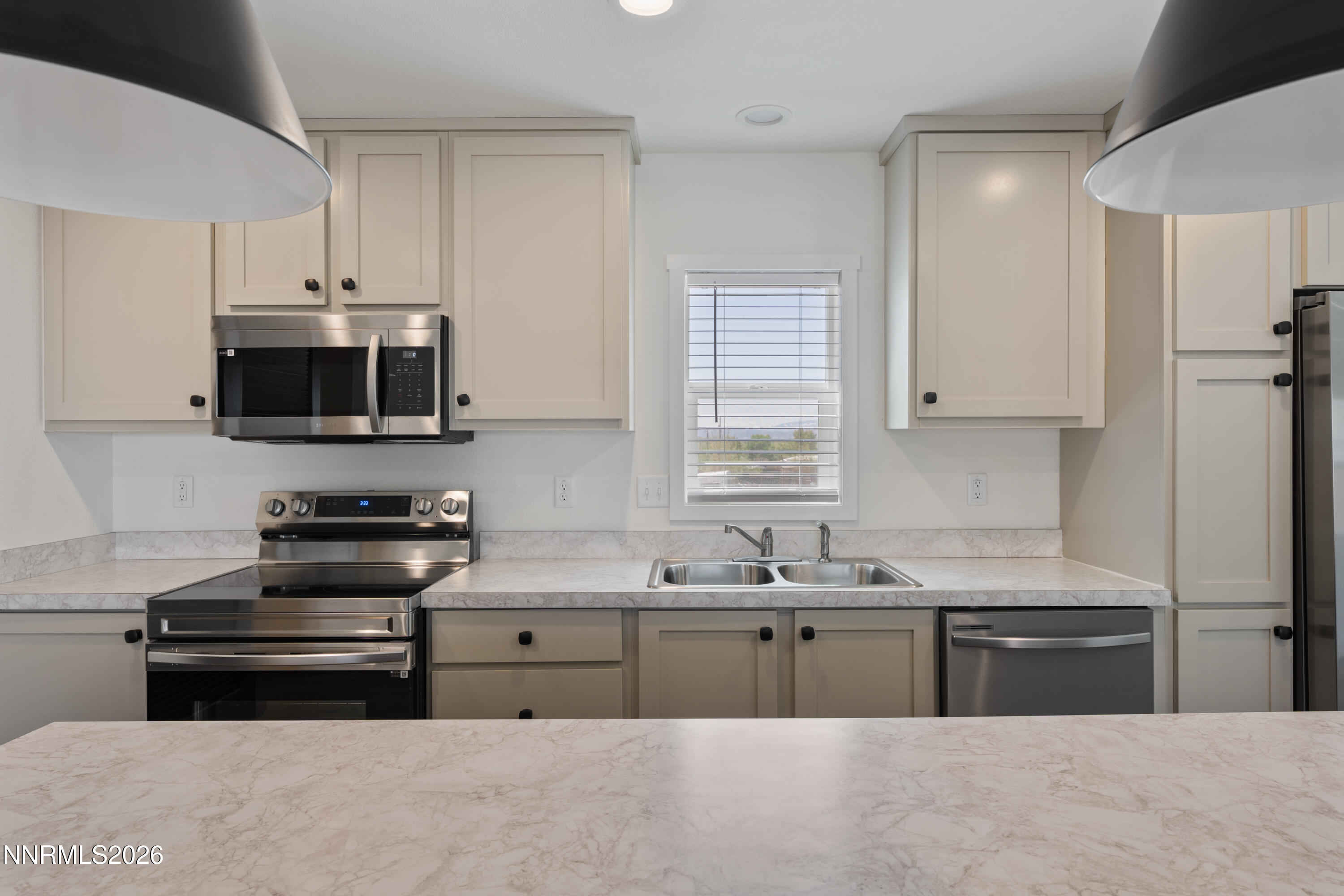 242 Caleb Court Sun Valley, NV 89433 - Photo 7 of 24 a kitchen with stainless steel appliances a stove a sink and a microwave