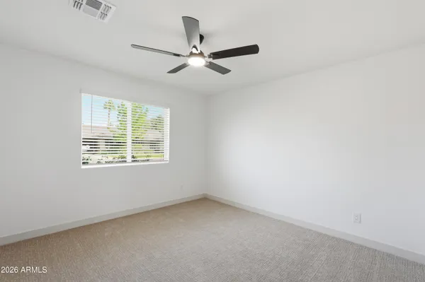 an empty room with a window and a fan