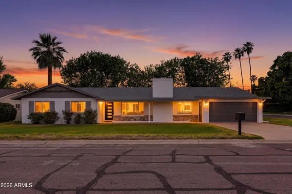 a front view of a house with a yard and a garage