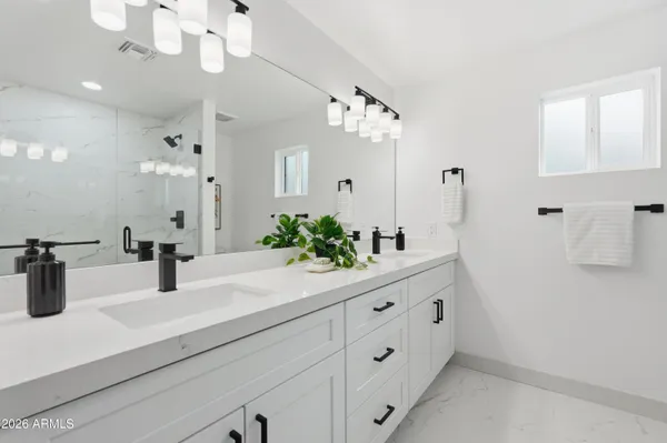 a bathroom with a sink a faucet a light fixture and a mirror