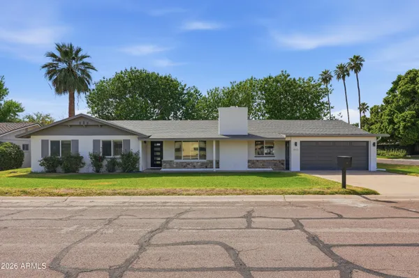 a front view of a house with a yard and trees