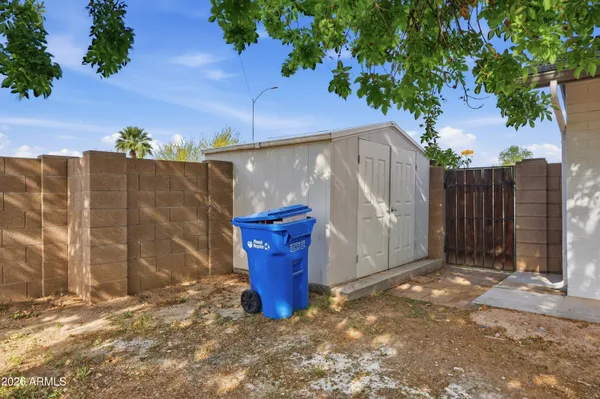 a view of a outdoor space with a tree and wooden fence