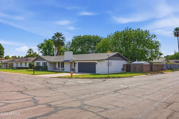 a front view of a house with a yard and trees
