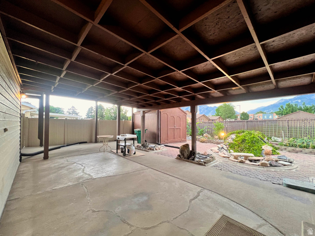 8097 South 535 East Sandy, UT 84070 - Photo 9 of 15 Expansive covered patio featuring a grid-patterned ceiling, concrete flooring, and an integrated brick-paver garden area