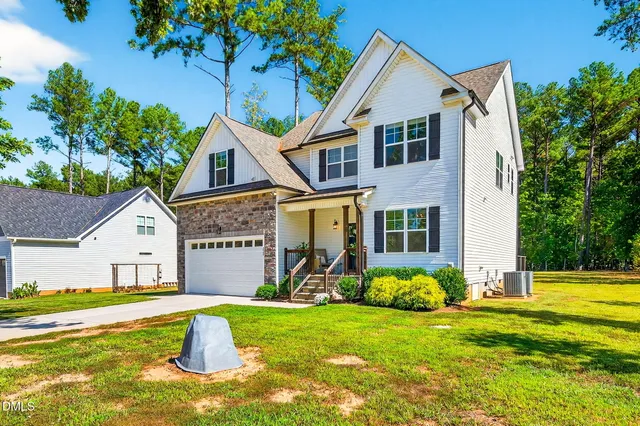 a view of a house with pool and a yard