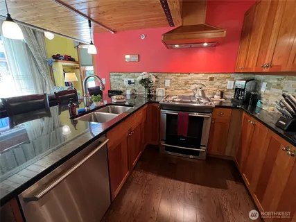 a kitchen with stainless steel appliances a sink stove and cabinets