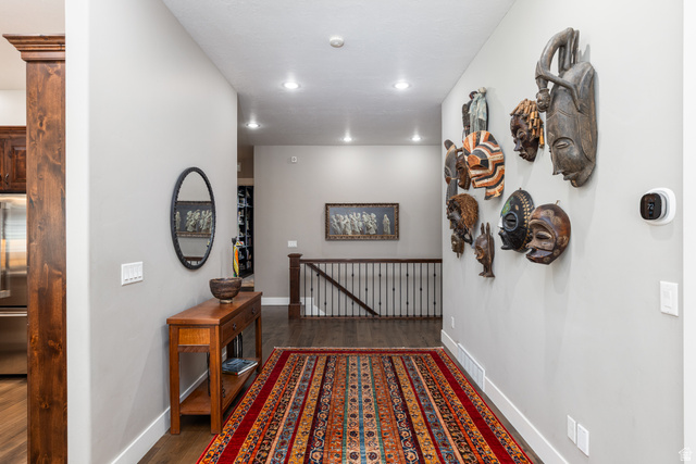 1132 Sunset Dunes Way Draper, UT 84020 - Photo 12 of 35 Hallway with recessed lighting, dark wood-finish flooring, light gray walls, white baseboards, and a dark wood staircase railing with black spindles