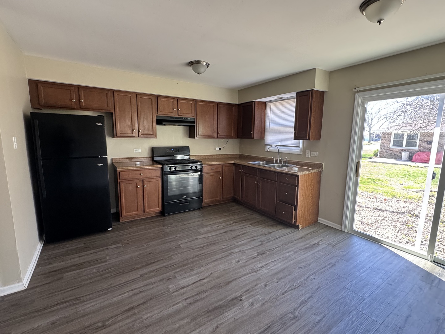 6021 Spring Lane Matteson, IL 60443 - Photo 2 of 14 a kitchen with stainless steel appliances granite countertop a refrigerator a stove top oven and sink