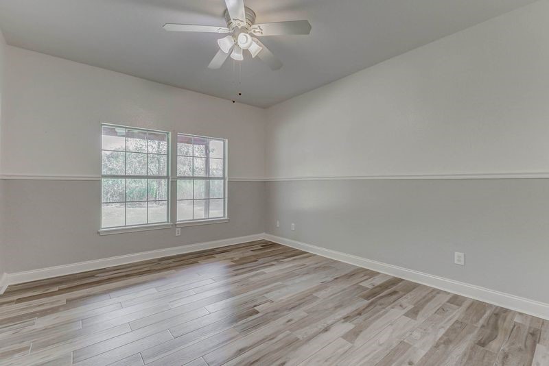 8411 Syms Street Fulshear, TX 77441 - Photo 21 of 29 wooden floor in an empty room with a window