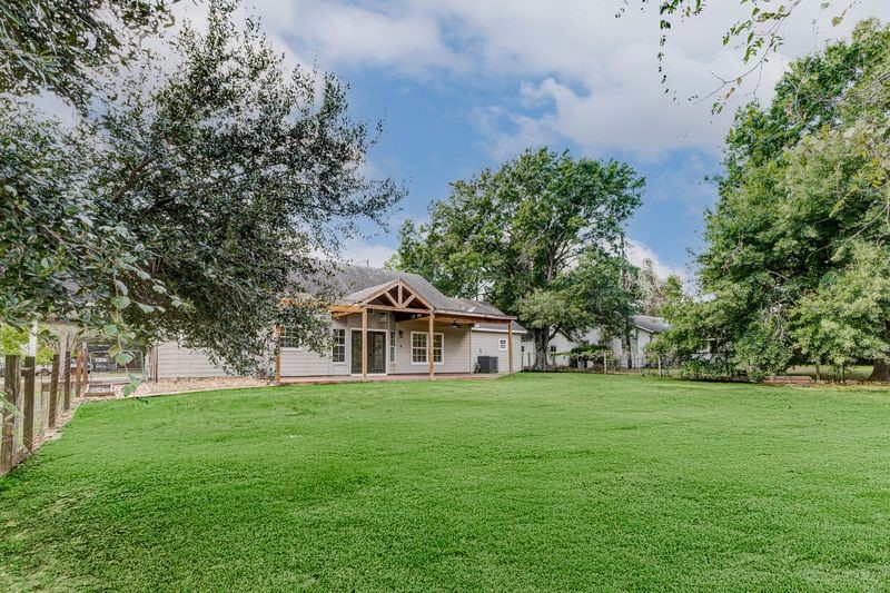 8411 Syms Street Fulshear, TX 77441 - Photo 27 of 29 a white house with a big yard and large trees