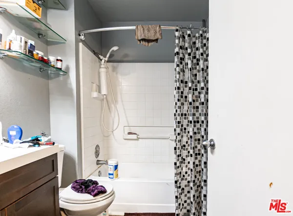 a bathroom with a sink a toilet and shower curtain