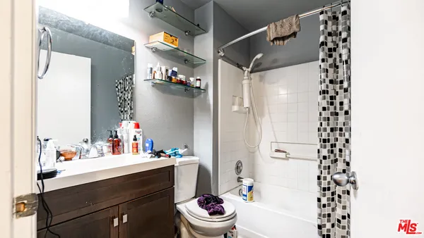 a bathroom with a sink a toilet and shower curtain
