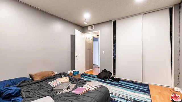 a bedroom with bed and a mirror