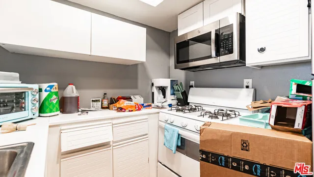 a kitchen with a microwave a stove and cabinets