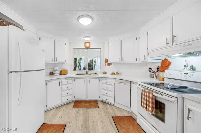 a kitchen with granite countertop white cabinets and white appliances