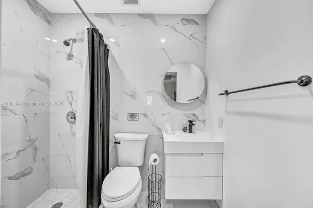 a bathroom with a sink toilet and shower
