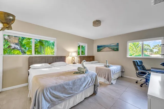 a room with two beds and a desk